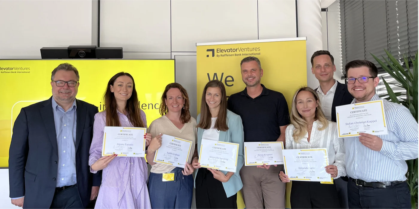 Group holding certificates at event backdrop