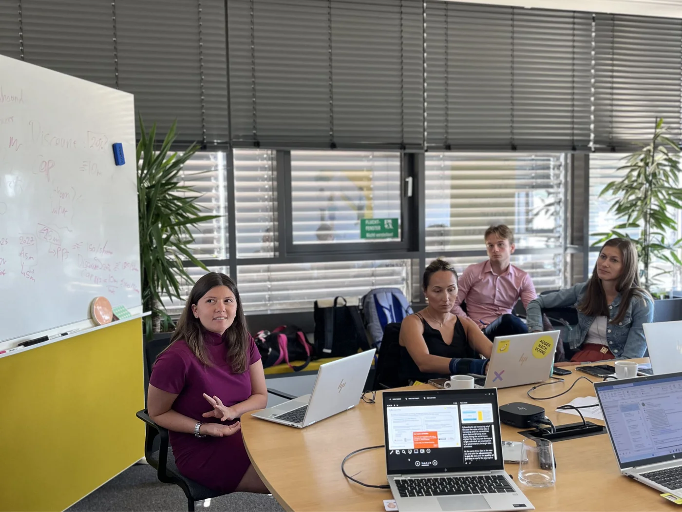 Team meeting with laptops and whiteboard