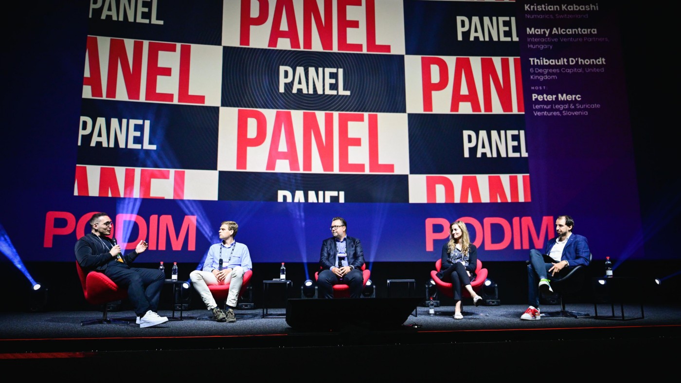 Panel of five speakers including Thomas Muchar on a stage